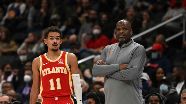 Trae Young standing beside Nate McMillan.